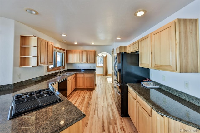 kitchen featuring light wood-type flooring, sink, light brown cabinets, and dark stone countertops