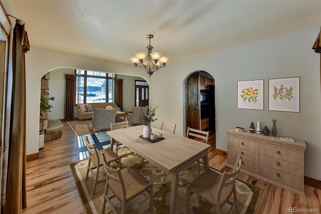 dining space with a chandelier and light hardwood / wood-style flooring