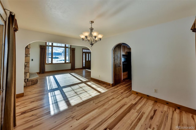 unfurnished dining area with light hardwood / wood-style flooring and a notable chandelier