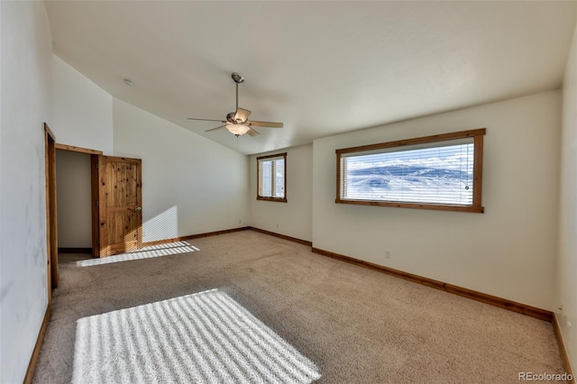 empty room featuring ceiling fan, light colored carpet, and lofted ceiling