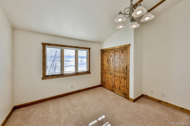 unfurnished bedroom with light colored carpet and lofted ceiling