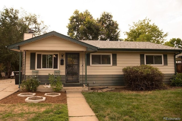 ranch-style home with covered porch and a front yard