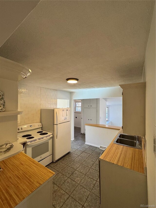 6213 Gray St, Arvada, CO 80003 - kitchen with white appliances, a sink, a textured ceiling, and light countertops
