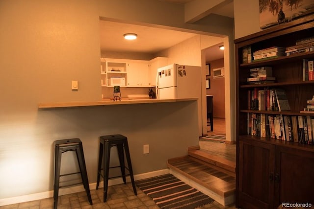 6213 Gray St, Arvada, CO 80003 - kitchen with white appliances, open shelves, baseboards, a kitchen bar, and white cabinets