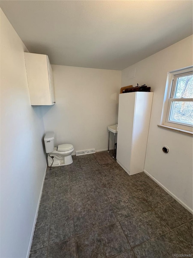 6213 Gray St, Arvada, CO 80003 - bathroom featuring toilet, baseboards, and vanity