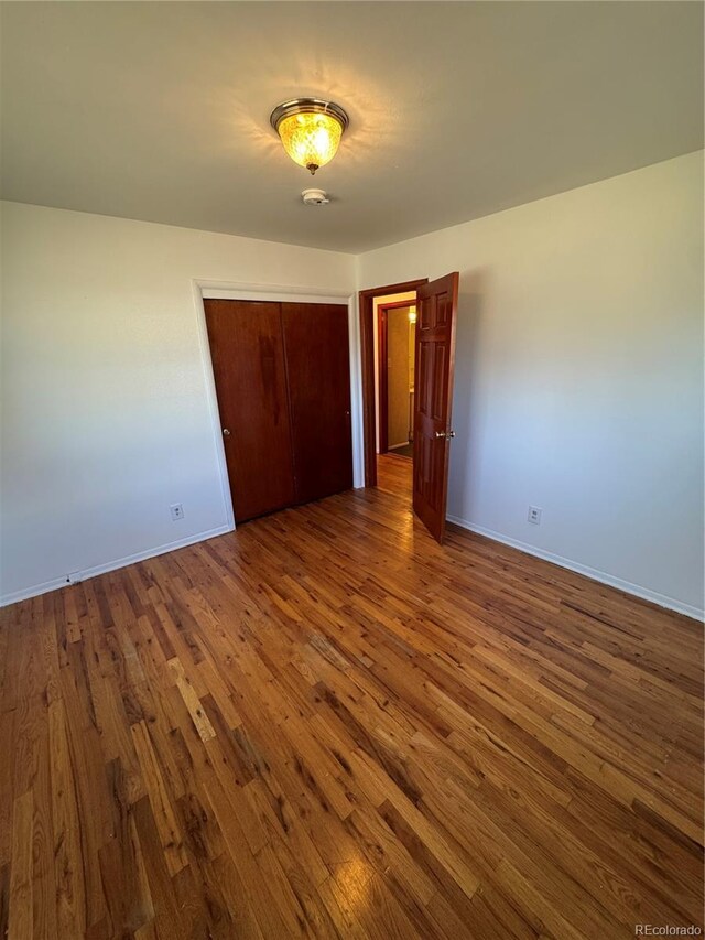 6213 Gray St, Arvada, CO 80003 - unfurnished bedroom with wood finished floors, a closet, and baseboards