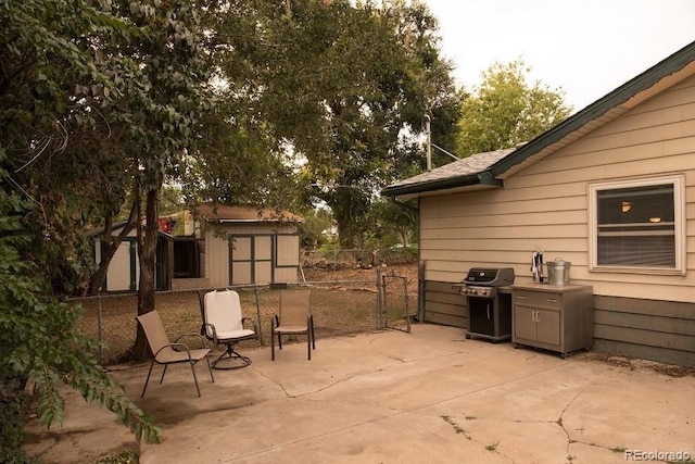 6213 Gray St, Arvada, CO 80003 - view of patio with a storage unit, a grill, an outdoor structure, and fence