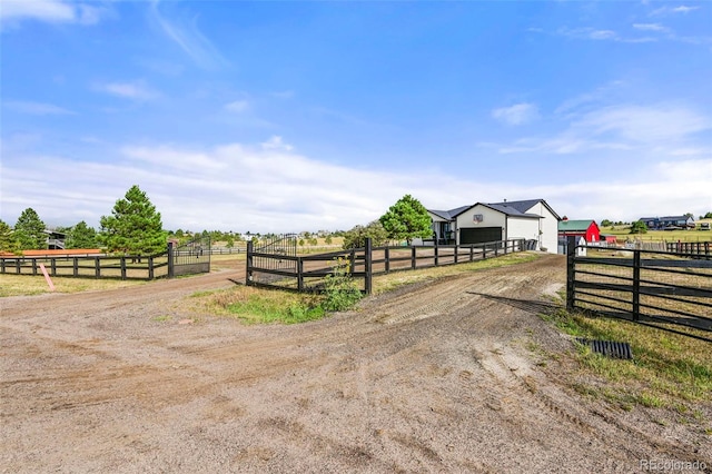 exterior space featuring driveway, a gated entry, and a rural view