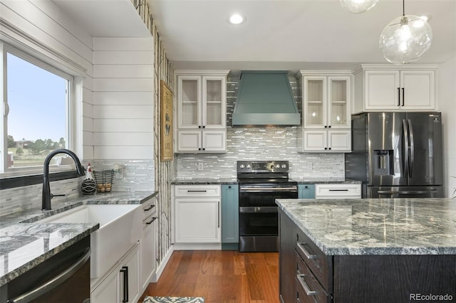 kitchen featuring white cabinets, stainless steel appliances, glass insert cabinets, and custom range hood