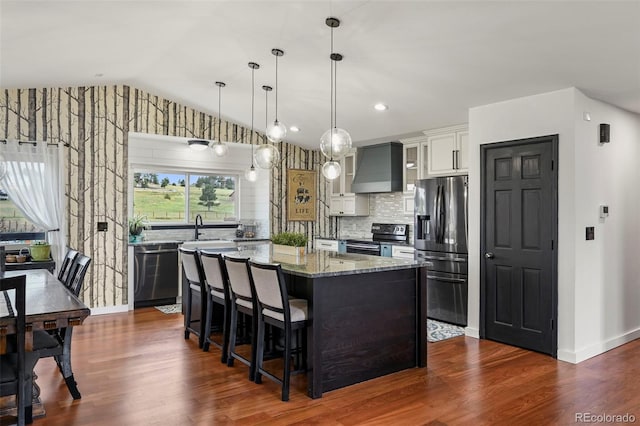 kitchen featuring custom range hood, stainless steel appliances, light stone countertops, lofted ceiling, and dark wood-type flooring