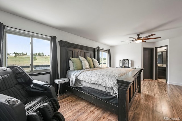 bedroom with a ceiling fan, connected bathroom, and wood finished floors