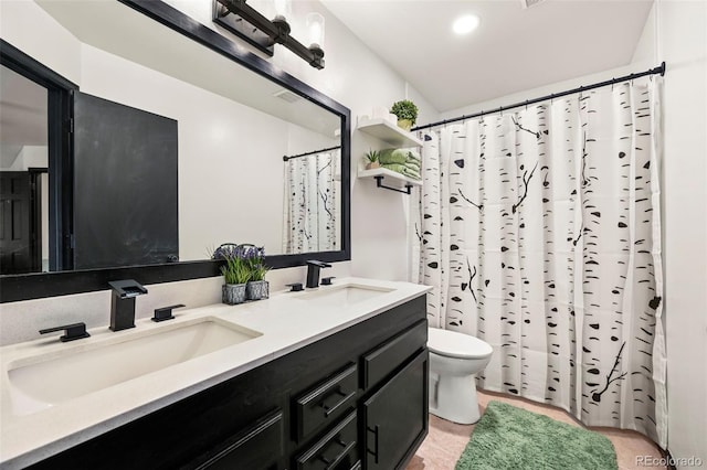 full bath with double vanity, visible vents, toilet, and a sink