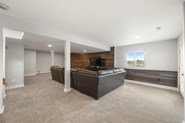 carpeted living room with wood walls