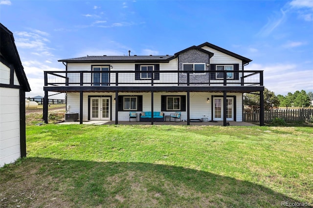 rear view of property featuring a balcony, a patio area, french doors, cooling unit, and a lawn