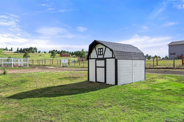 view of outdoor structure featuring a rural view and a yard