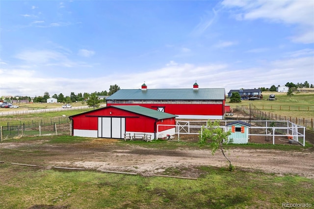 view of pole building featuring a rural view and fence