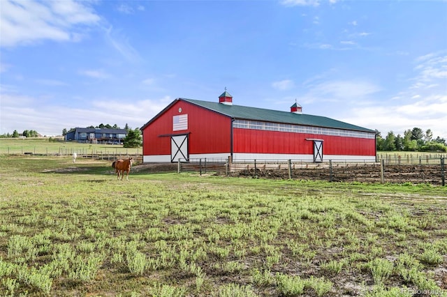 view of outbuilding with a rural view and a lawn