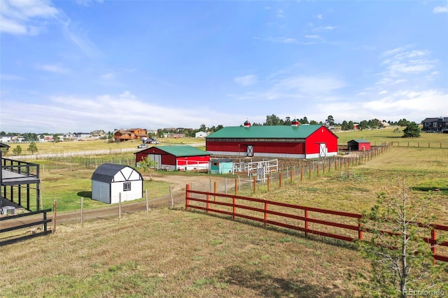 view of yard with an outbuilding, a rural view, and fence