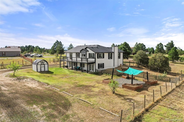 exterior space featuring a storage shed, an outdoor structure, fence, and a garden