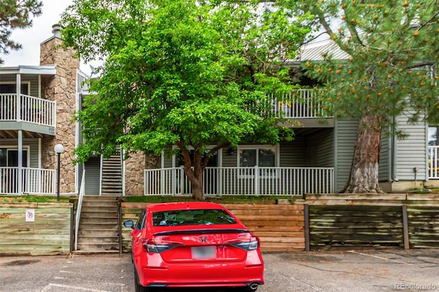 910 S Walden St Unit 106, Aurora, CO 80017 - view of front of property with covered porch, stone siding, and a balcony
