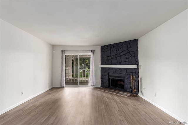 910 S Walden St Unit 106, Aurora, CO 80017 - unfurnished living room with wood finished floors, a fireplace, and baseboards