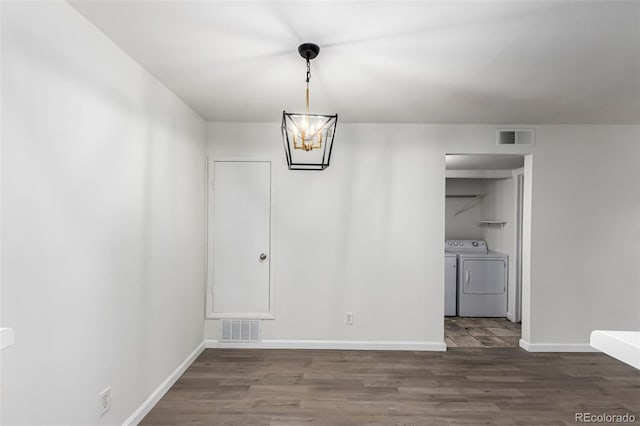 910 S Walden St Unit 106, Aurora, CO 80017 - unfurnished dining area featuring a chandelier, independent washer and dryer, wood finished floors, and baseboards