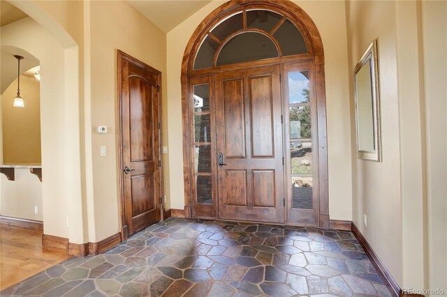 28800 Stonecrop Trl, Conifer, CO 80433 - entryway featuring baseboards, dark stone finish flooring, and arched walkways