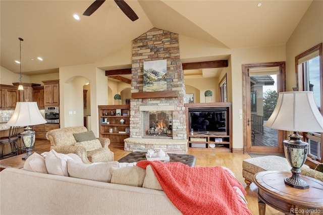 28800 Stonecrop Trl, Conifer, CO 80433 - living area with a fireplace, light wood-type flooring, a ceiling fan, arched walkways, and vaulted ceiling