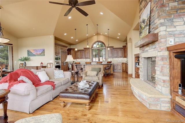 28800 Stonecrop Trl, Conifer, CO 80433 - living area featuring a ceiling fan, light wood-style flooring, a stone fireplace, high vaulted ceiling, and recessed lighting