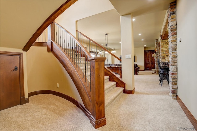 28800 Stonecrop Trl, Conifer, CO 80433 - stairway featuring carpet flooring, baseboards, recessed lighting, a chandelier, and a fireplace