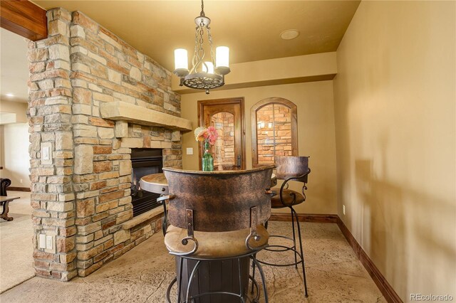 28800 Stonecrop Trl, Conifer, CO 80433 - bar featuring baseboards, a stone fireplace, and a chandelier