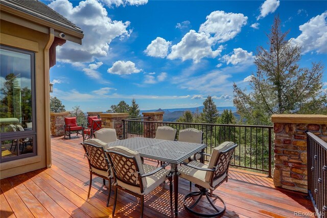 28800 Stonecrop Trl, Conifer, CO 80433 - wooden deck featuring outdoor dining area and a mountain view
