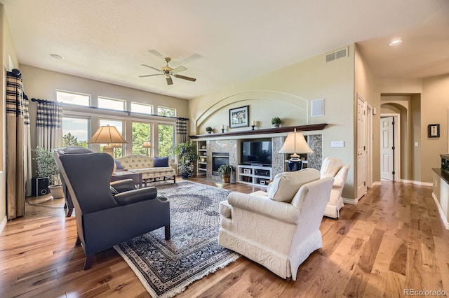 11070 Meade Ct, Westminster, CO 80031 - living area with a ceiling fan, wood finished floors, a tiled fireplace, arched walkways, and recessed lighting