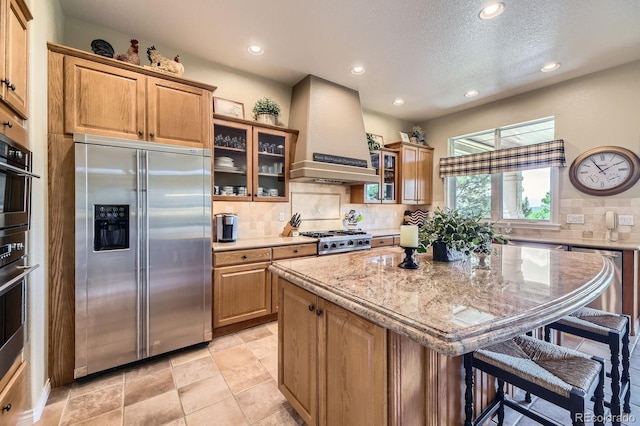 11070 Meade Ct, Westminster, CO 80031 - kitchen with stainless steel appliances, premium range hood, a kitchen bar, recessed lighting, and a kitchen island