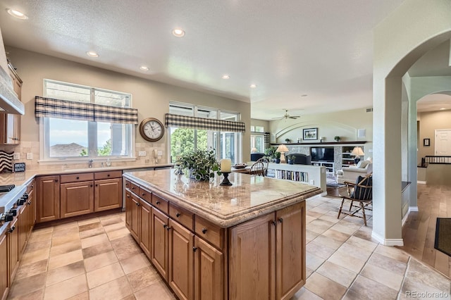 11070 Meade Ct, Westminster, CO 80031 - kitchen with arched walkways, ceiling fan, recessed lighting, backsplash, and brown cabinetry