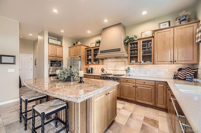11070 Meade Ct, Westminster, CO 80031 - kitchen featuring custom exhaust hood, a kitchen bar, appliances with stainless steel finishes, decorative backsplash, and a center island