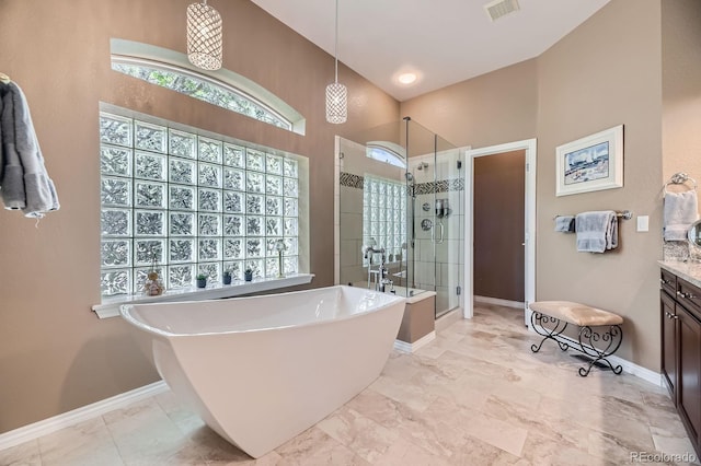11070 Meade Ct, Westminster, CO 80031 - full bathroom featuring a stall shower, a freestanding bath, vanity, plenty of natural light, and a towering ceiling