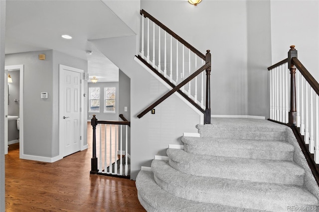 stairs featuring wood finished floors and baseboards