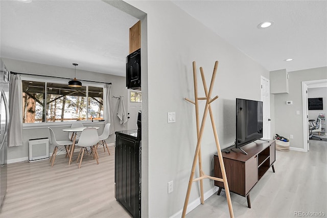 interior space featuring a textured ceiling, recessed lighting, light wood-type flooring, and baseboards