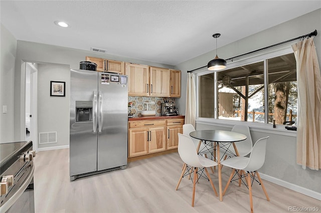 kitchen featuring tasteful backsplash, visible vents, appliances with stainless steel finishes, and pendant lighting