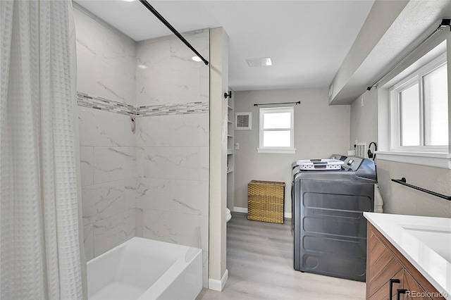 full bath with shower / tub combo, visible vents, baseboards, wood finished floors, and vanity