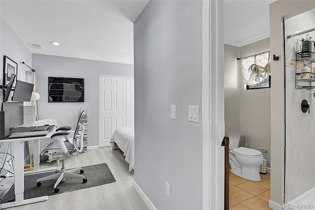 office area with light wood-type flooring, visible vents, and baseboards