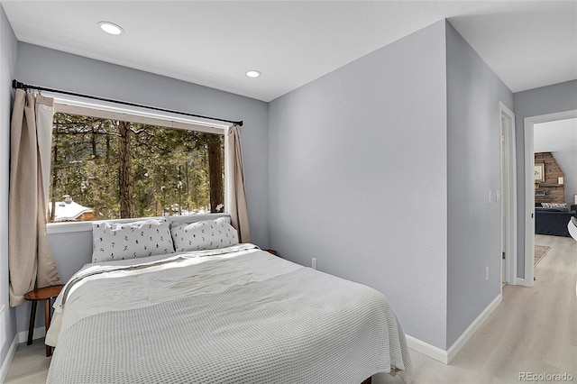 bedroom with light wood-type flooring, baseboards, and recessed lighting