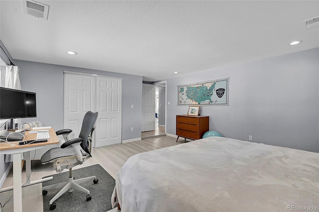 bedroom with recessed lighting, a closet, visible vents, and light wood finished floors