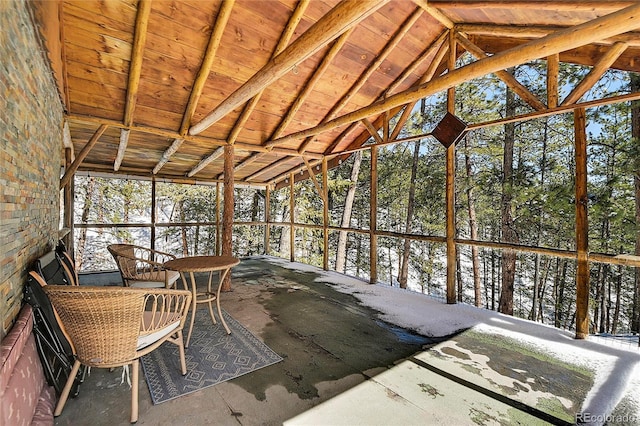 unfurnished sunroom featuring vaulted ceiling