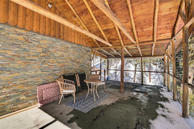 unfurnished sunroom featuring lofted ceiling with beams and wooden ceiling