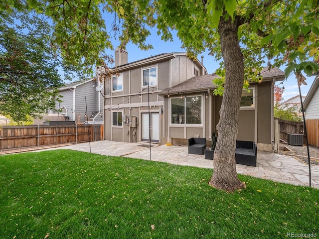 back of property with a yard, a patio, and central air condition unit