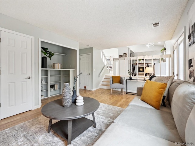 living room with a textured ceiling and light wood-type flooring