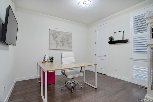 home office with visible vents, dark wood-type flooring, and baseboards