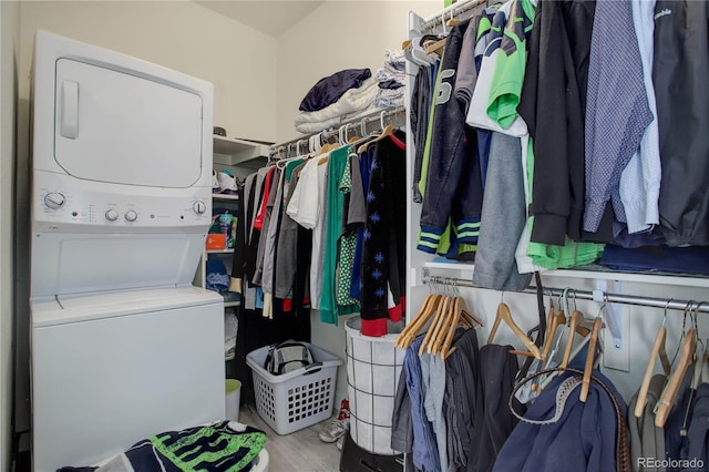 spacious closet with wood finished floors and stacked washer and clothes dryer